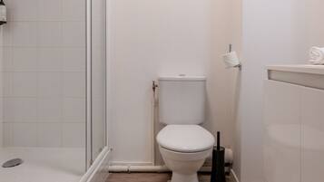 Une salle de bain moderne équipée d’une douche, de toilettes et d’un lavabo.