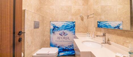 Un baño con inodoro, lavamanos y cortina de ducha con diseño abstracto azul.