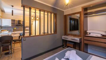 Una habitación de hotel moderna con una cama, un escritorio, una silla y un baño con espejo y toallero.