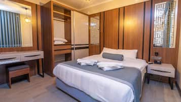 Ein modernes Hotelzimmer mit einem großen Bett, einem Schreibtisch und einem begehbaren Kleiderschrank.
