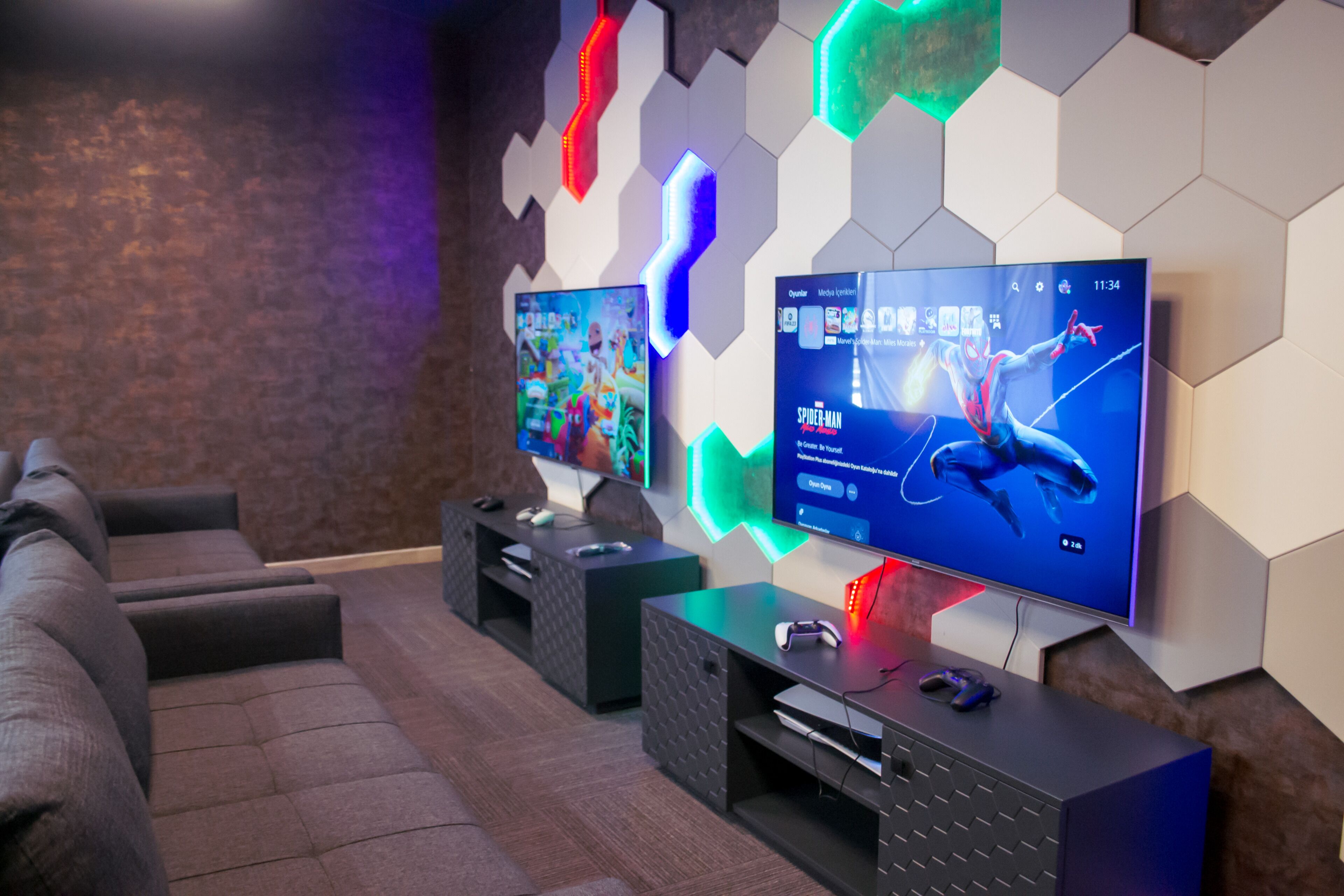 A modern living room with a large flat-screen TV displaying a movie, a gaming console, and a comfortable seating area.
