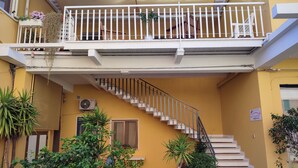 Un edificio de varios pisos con una escalera que lleva a un balcón.