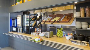 A breakfast bar with various food items, a coffee machine, and a toaster.