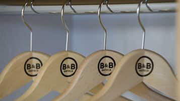 Four wooden hangers with the logo "B&B Hotels" on a metal rack.