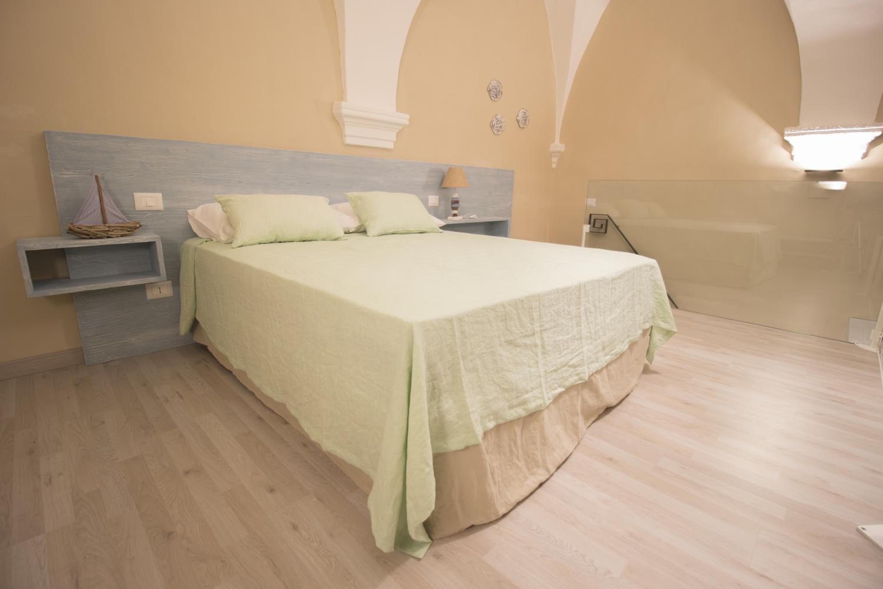 A bedroom with a bed, bedside tables, and a nightstand.