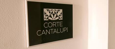 Un letrero con el texto 'CORTE CANTALUPI' en una pared.