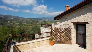 A stone building with a balcony overlooking a scenic valley. - Old Olive Mill House by TrulyCyprus (Dhoros)
