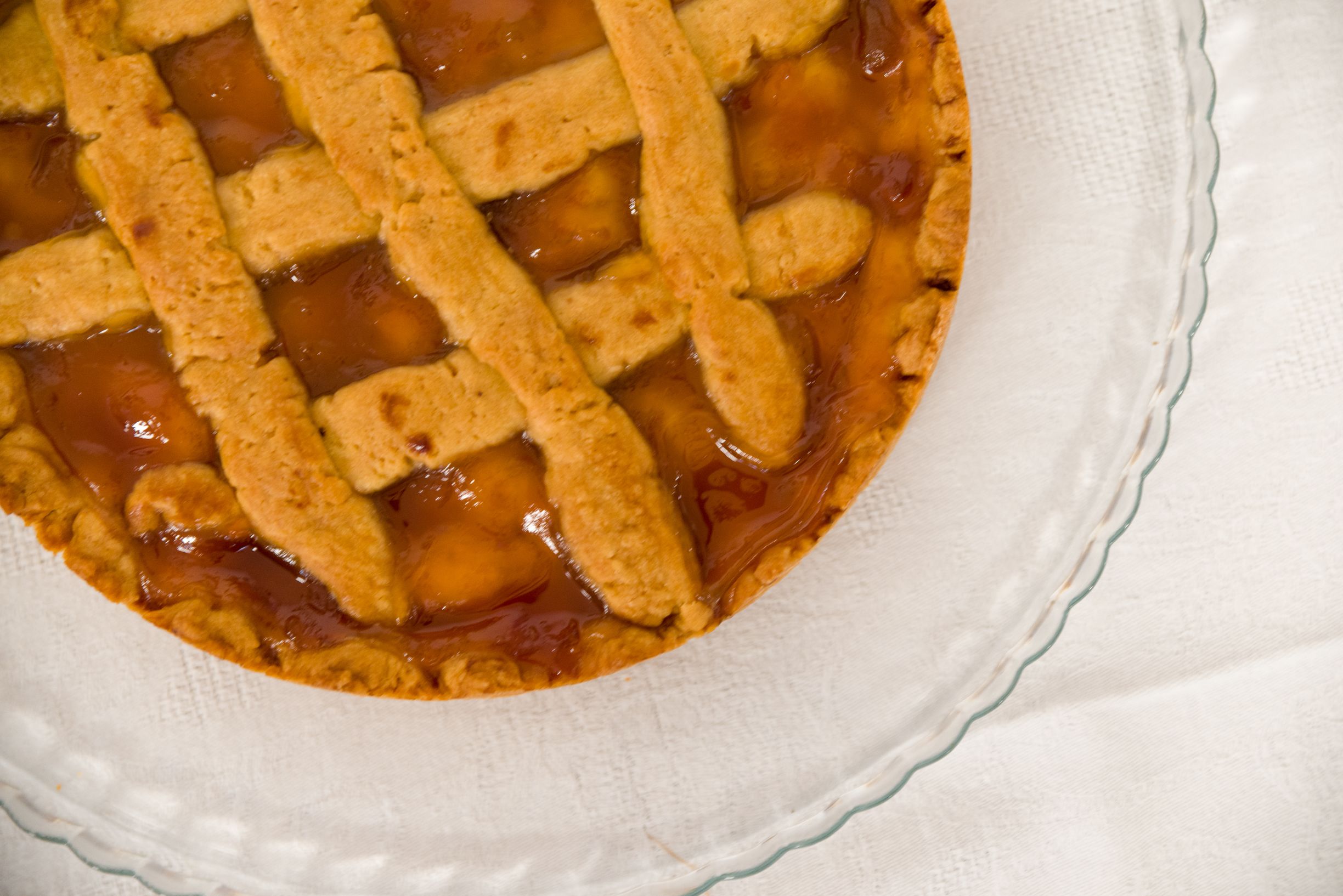 Tarta de frutas con corteza entrelazada sobre un plato blanco.