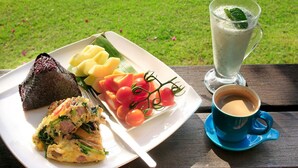 A meal with a slice of bread, a vegetable dish, and a cup of coffee on a table with a grassy background. - Moonrise Inn (Donghe)