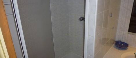 A bathroom with a shower, a sink, and a mirror.