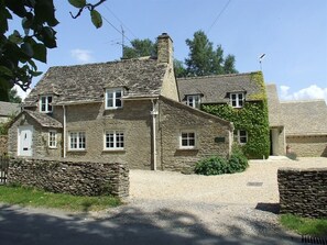 A stone house with a gravel driveway and a stone wall. - Well Cottage B&B (Cirencester)
