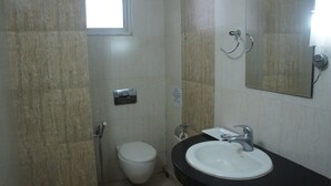 Een kleine badkamer met toilet, wastafel en spiegel.