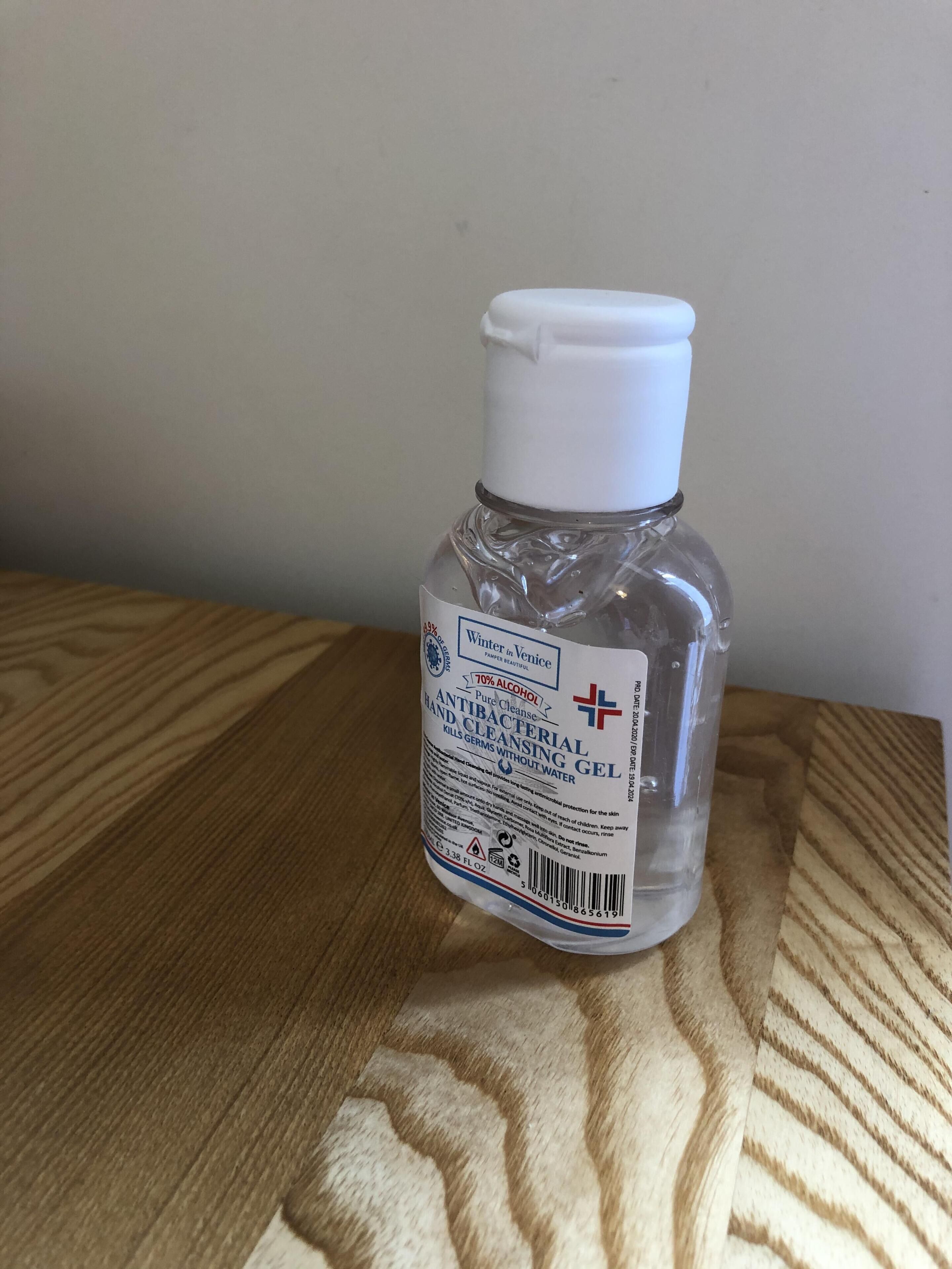 A bottle of hand cleansing gel on a wooden surface.