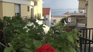 A residential building with a balcony overlooking a body of water. - Natalie Apartments (Sithonia)