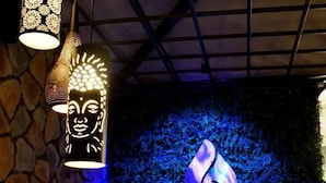 A reception area with a stone wall, a blue-lit backdrop, and a logo for 'FLAMEUP'. - JD Hotel Four Boutique (Jaipur)