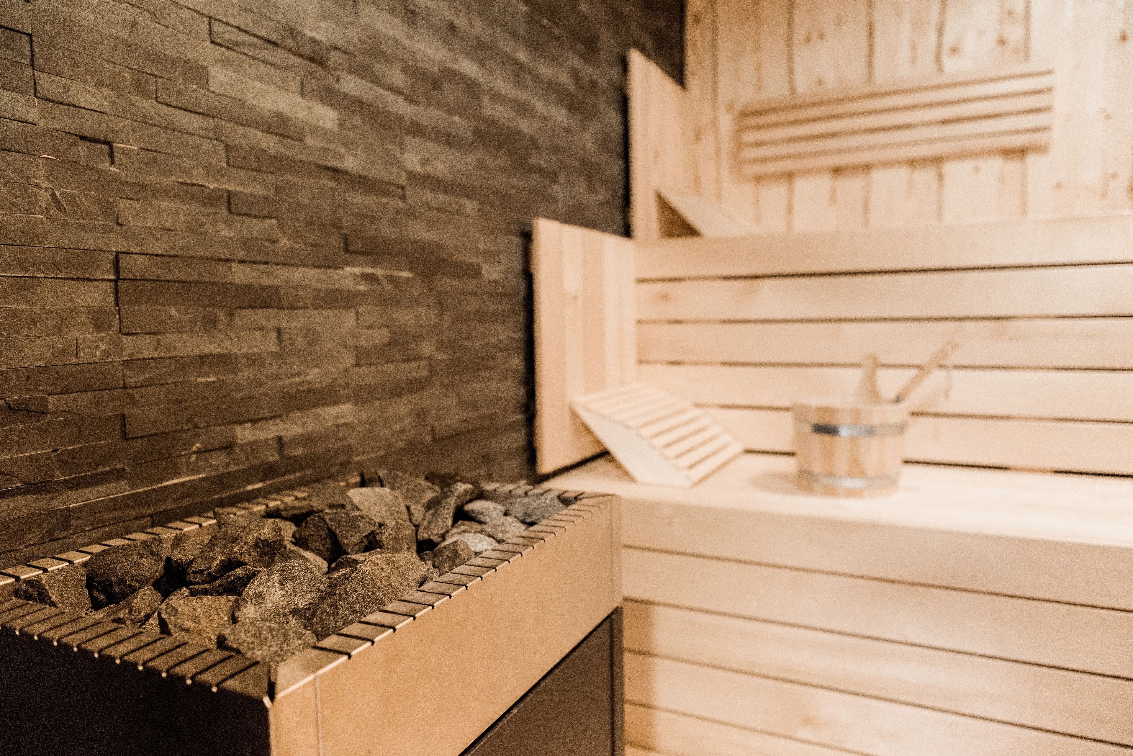 Una sauna con pared de ladrillo y bancos de madera.