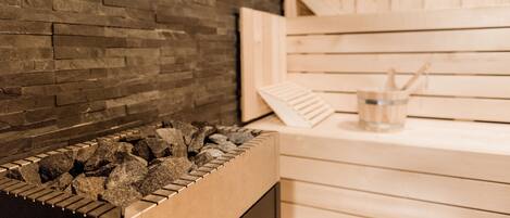 Una sauna con pared de ladrillo y bancos de madera.