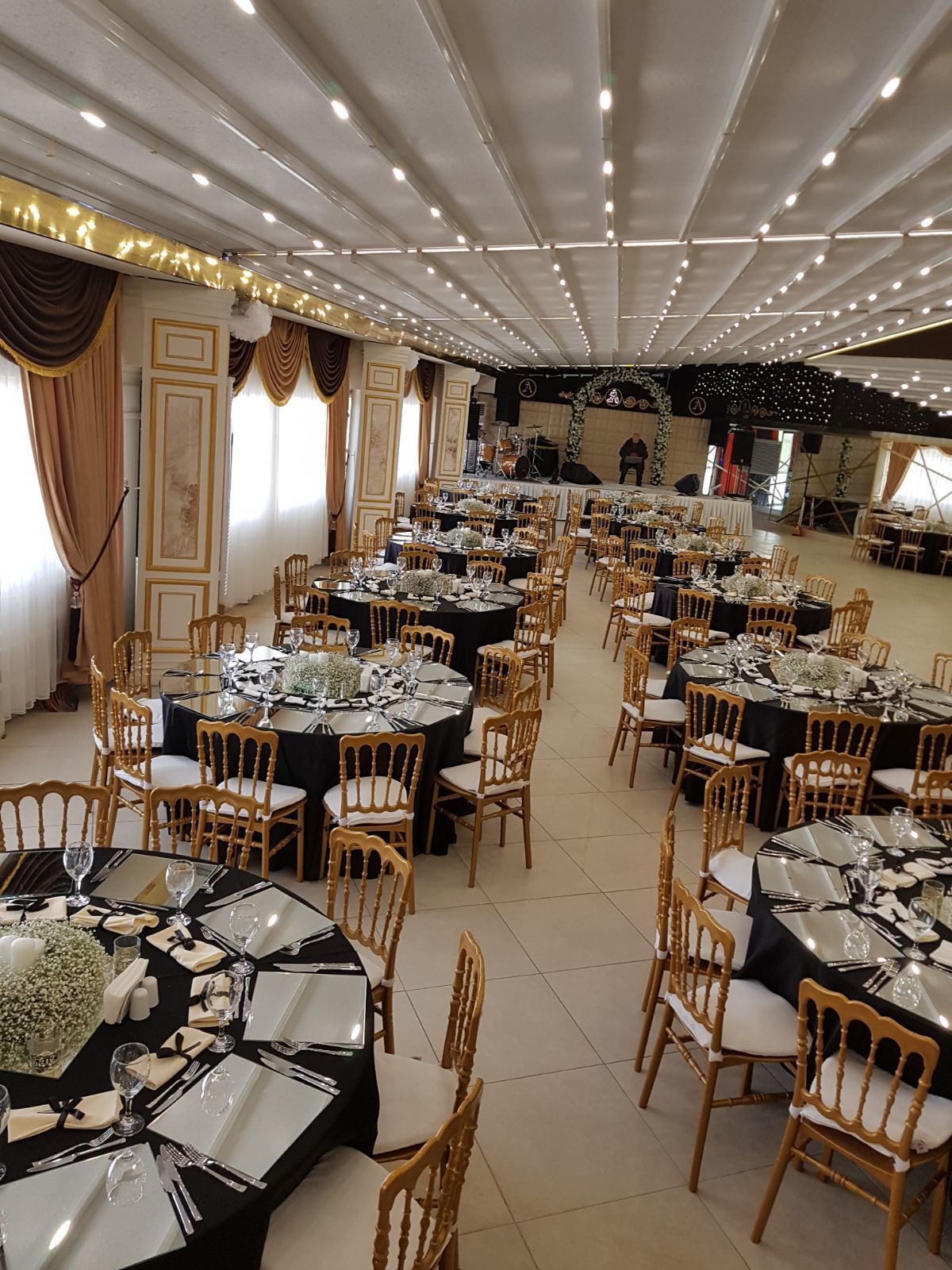 A banquet hall with round tables set for dining, equipped with chairs and table settings.