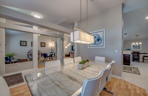 Enjoy meals in this stylish dining area with a large table, comfortable chairs, and beautiful artwork on the walls.