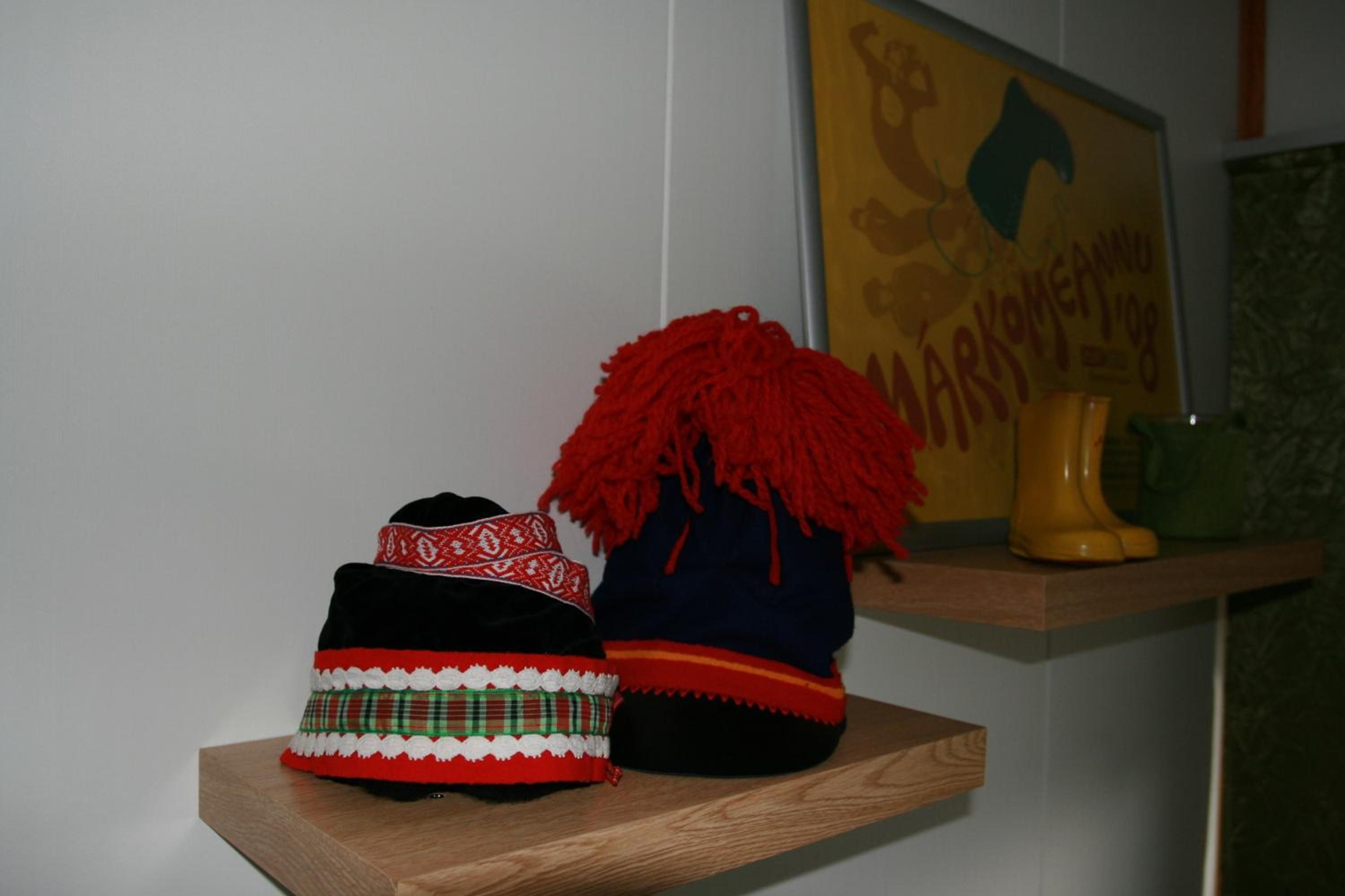 Une étagère avec deux chapeaux traditionnels et une botte jaune.