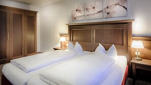 A hotel room with a large bed, two bedside tables, a wardrobe, and wall art. - Himmel Landshut Hotel-Restaurant-Cafe (Landshut)