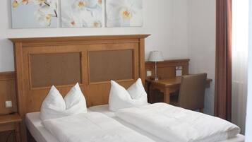 Ein Doppelbett mit Holz Kopfteil, ein Nachttisch, eine Lampe und ein Sessel.