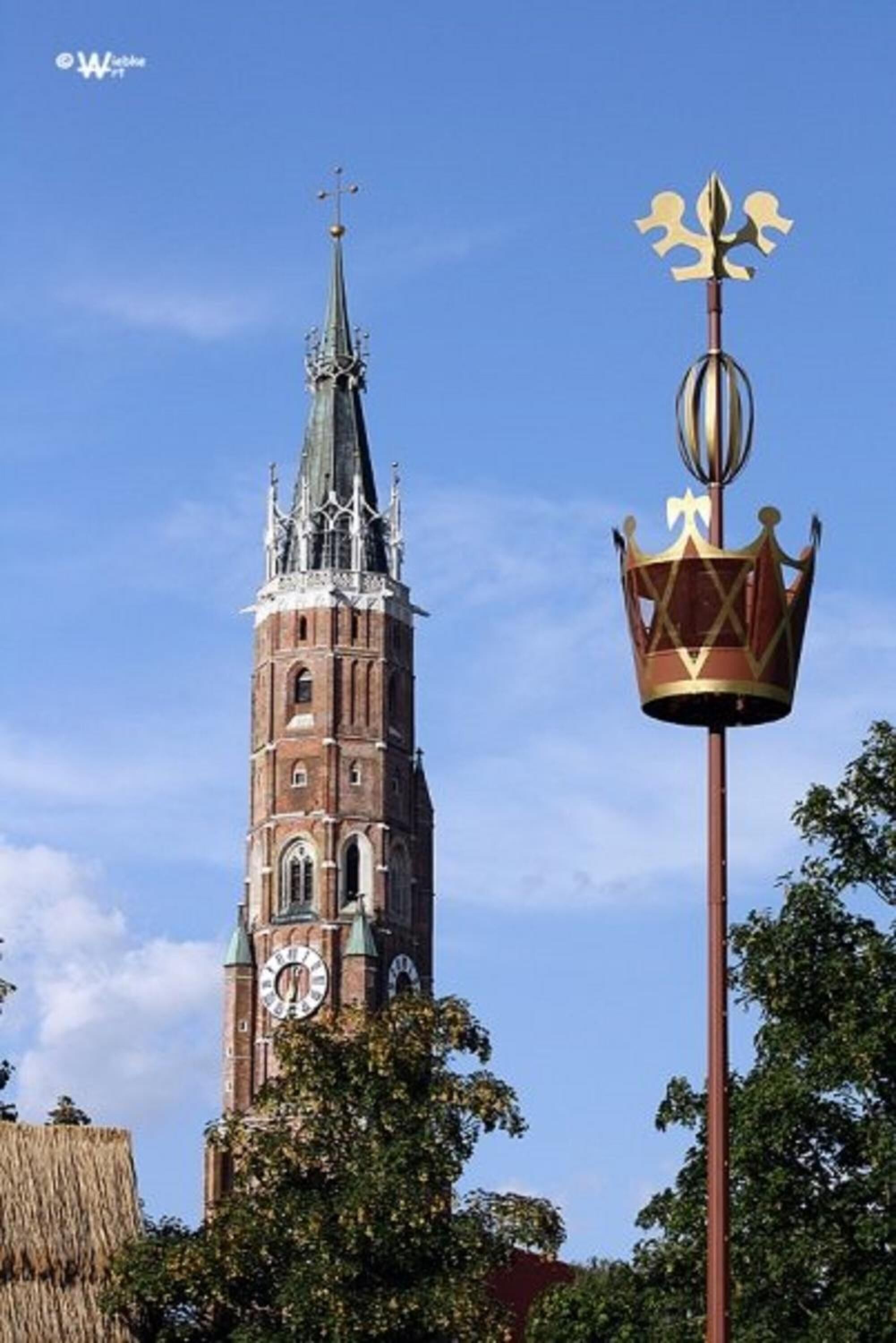 A church tower with a clock and a weather vane.