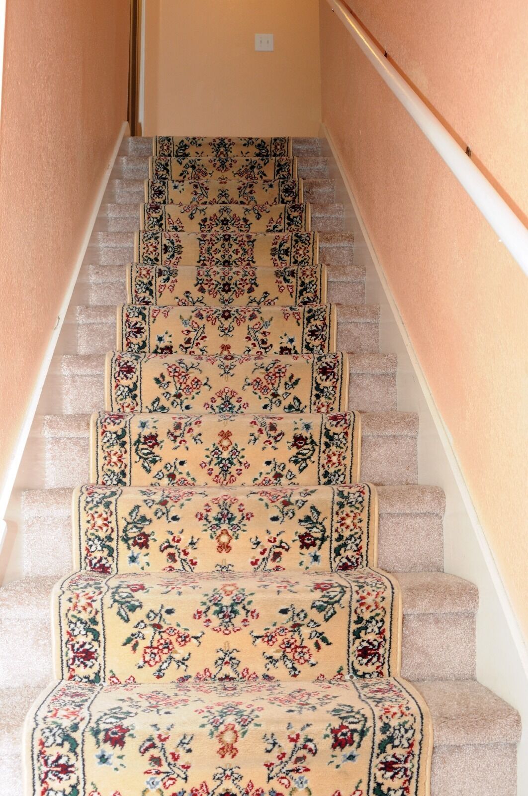 Eine Treppe mit Teppichstufen, verziert mit einem floralen Muster.