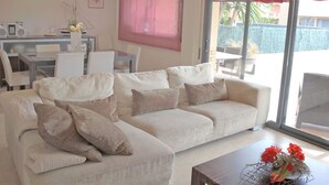 Un salon comprenant un canapé, une table basse et un coin repas avec des chaises et une table.