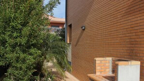 Un mur de briques avec un banc et un petit espace jardin agrémenté de plantes et de fleurs.