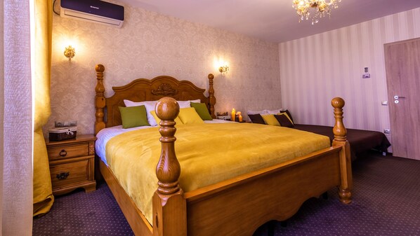 A neatly arranged bedroom with a large wooden bed, bedside lamps, and a wall-mounted air conditioner. - Hermannstadt House1 (Sibiu)