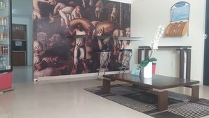 A lobby with a red telephone booth, a beverage vending machine, a mural, a reception desk, and a map display. - Hotel Aracaju Express (Aracaju)