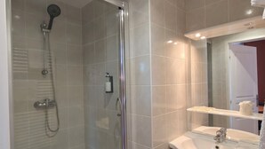 A modern bathroom with a glass-enclosed shower, a white sink, and a mirror above it. - Hôtel Le Catalan (La Cabanasse)