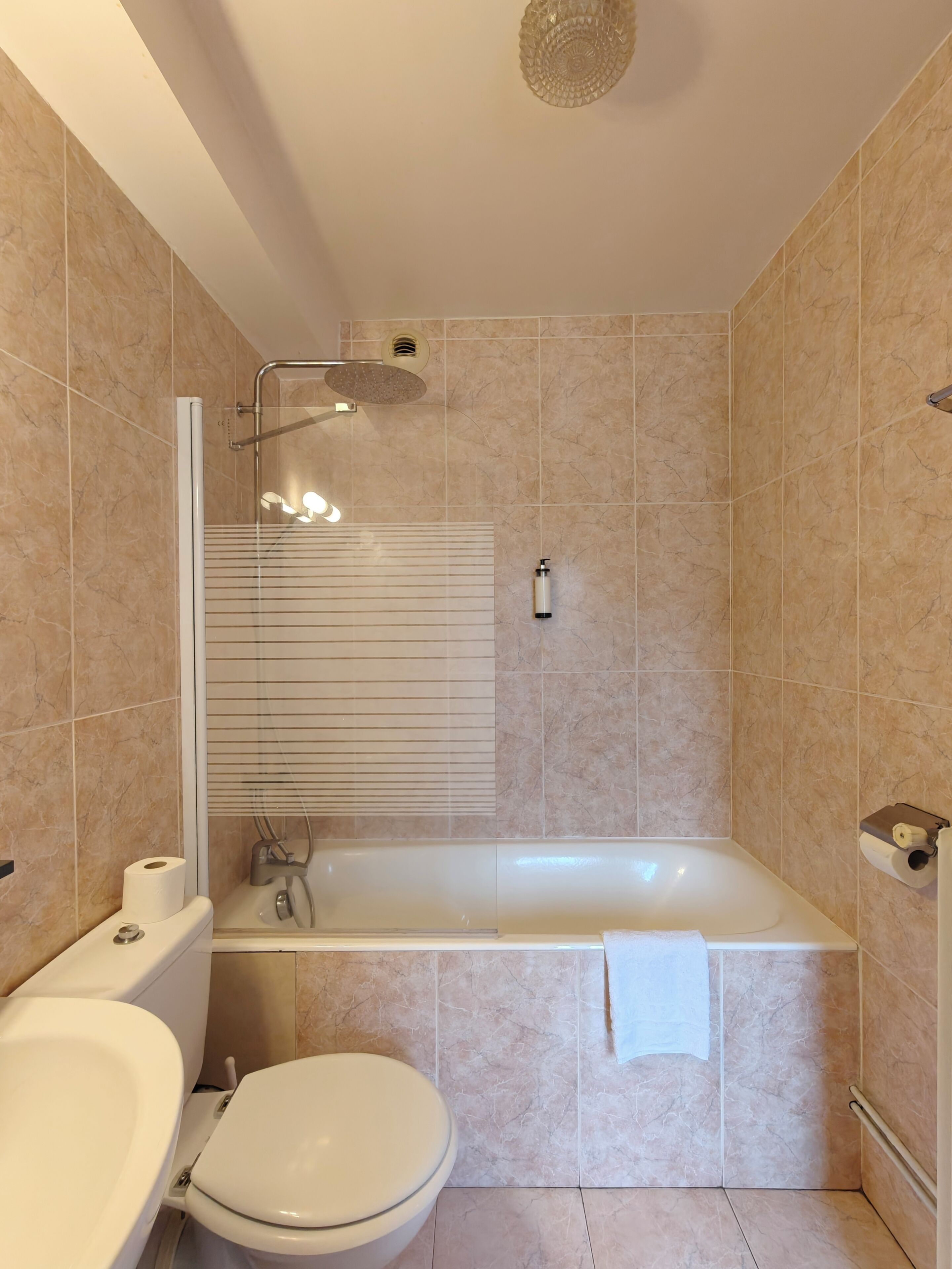 Un baño moderno con bañera, inodoro y ducha.