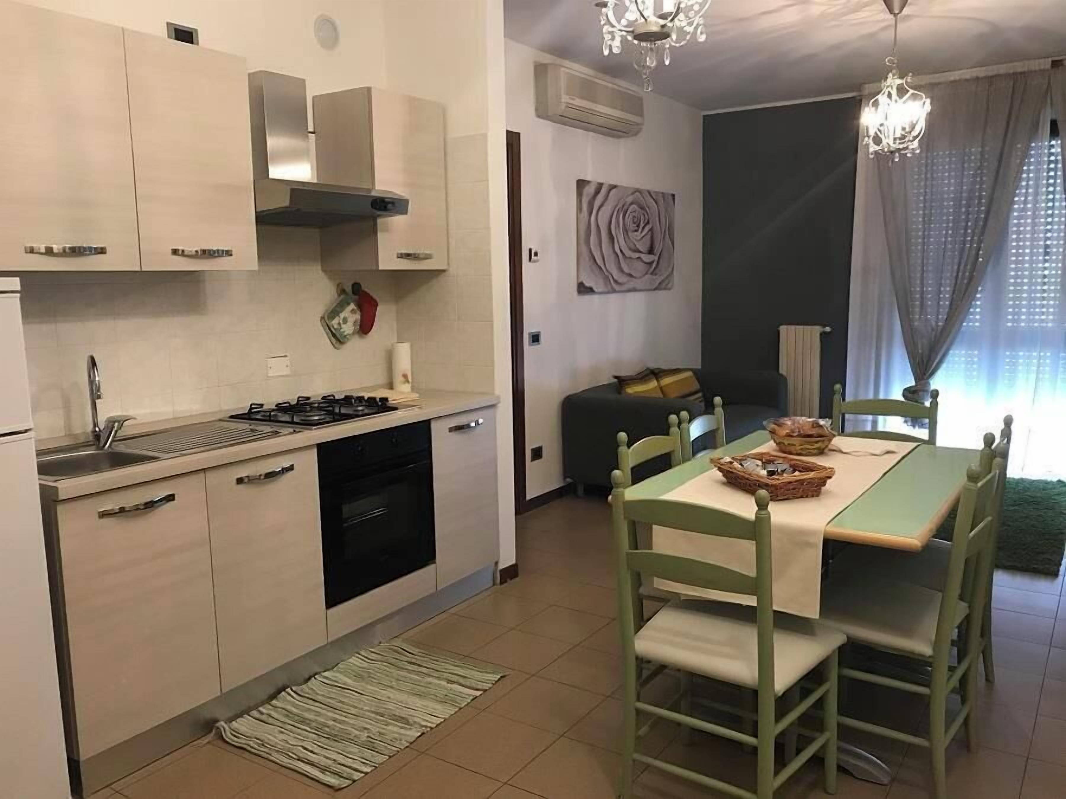 Una cocina moderna con estufa a gas, pileta y comedor con mesa y sillas.