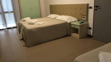 Een hotelkamer met een groot bed, een nachtkastje en een groene garderobe.