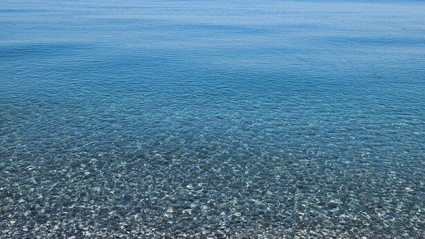 A clear view of a beach with calm water and visible pebbles. - Camping Ulisse (Lamezia Terme)