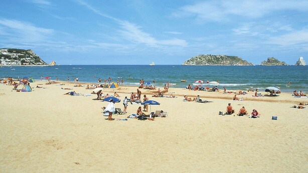 A beach with people sunbathing and swimming, tents, and umbrellas. - Lovely apartment for 4 people with A/C, WIFI, TV and terrace (Torroella De Montgrí)