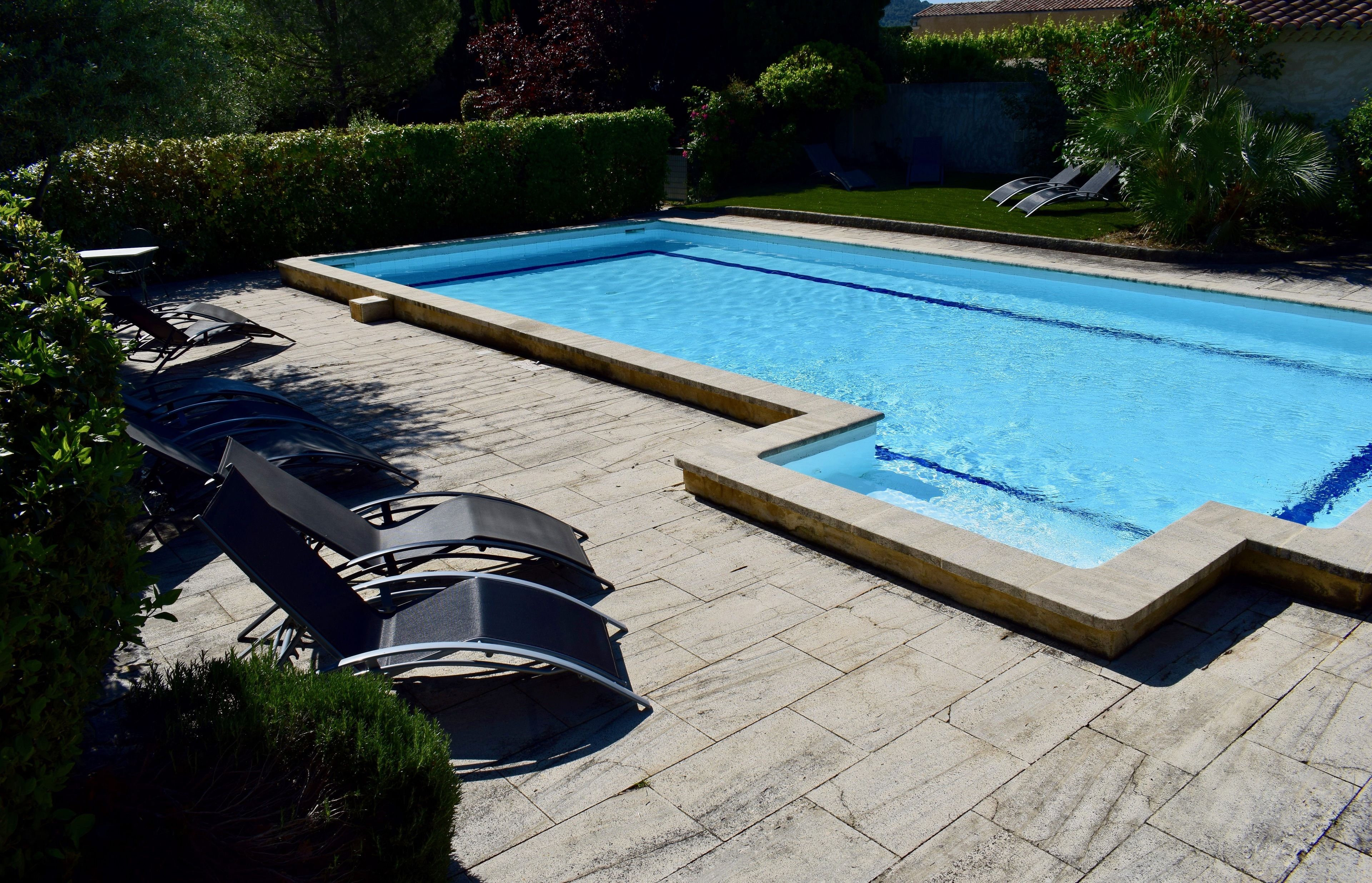 Una piscina al aire libre de temporada, sombrillas
