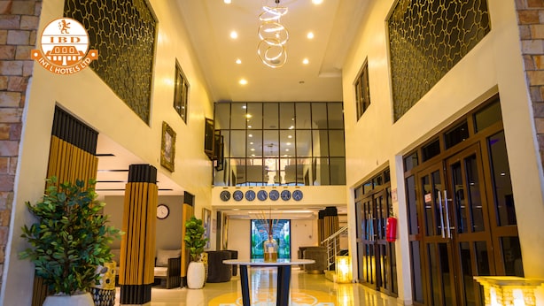 A hotel lobby with a central round table, large potted plants, and a modern chandelier. - IBD International Hotels Limited (Abeokuta)