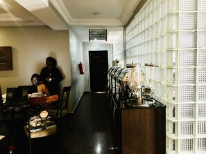 A hallway with a row of glass-fronted cabinets, a fire extinguisher on the wall, and a door at the end. - IBD International Hotels Limited (Abeokuta)