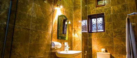 A bathroom with a sink, toilet, and shower.