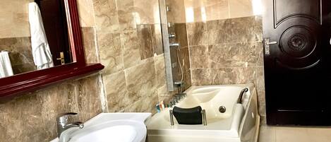 Un bagno con un lavandino bianco, una vasca e uno specchio.