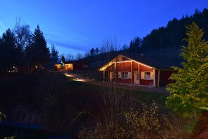 Ett hus med en röd fasad och ett upplyst julgran.