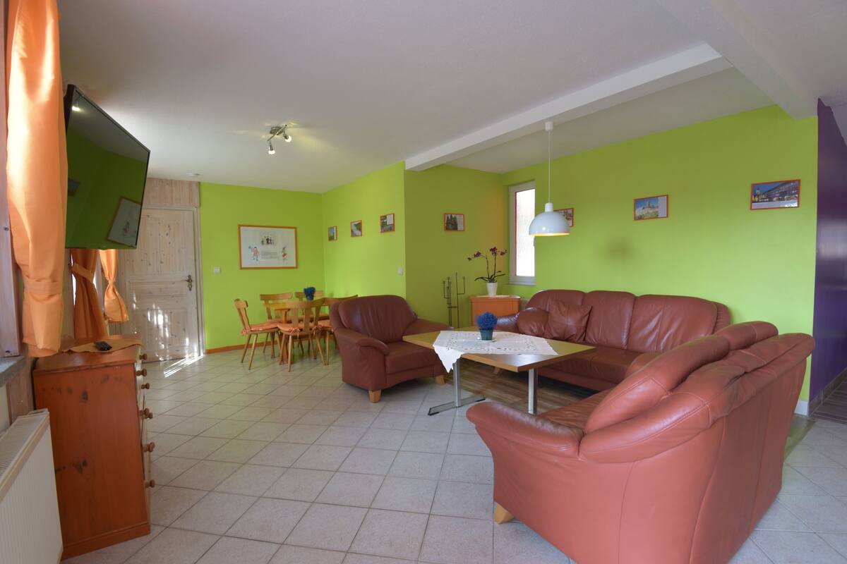 Een woonkamer met een bank, een salontafel en een televisie.