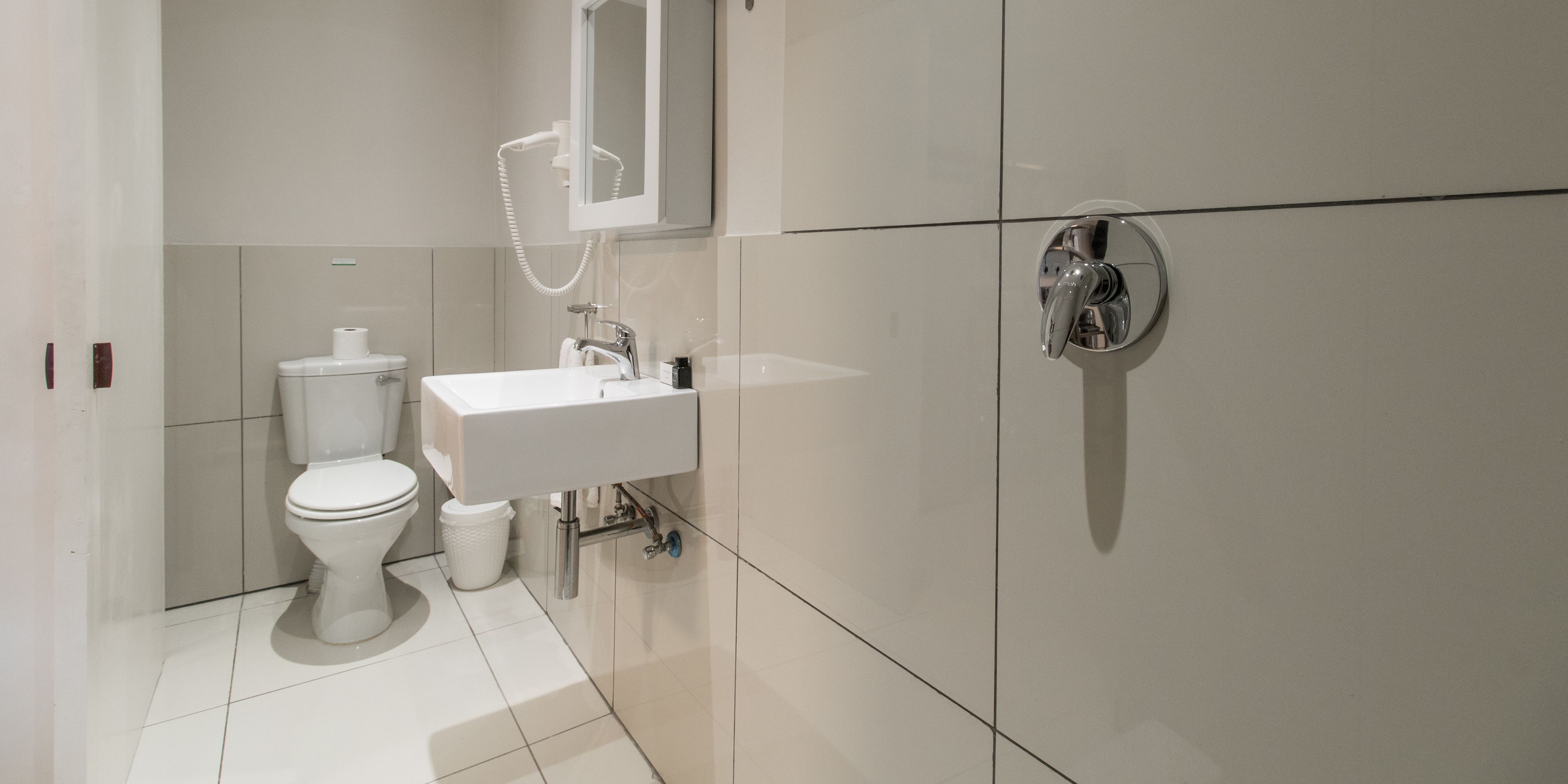 Une salle de bain moderne équipée de toilettes, d’un lavabo et d’une douche.
