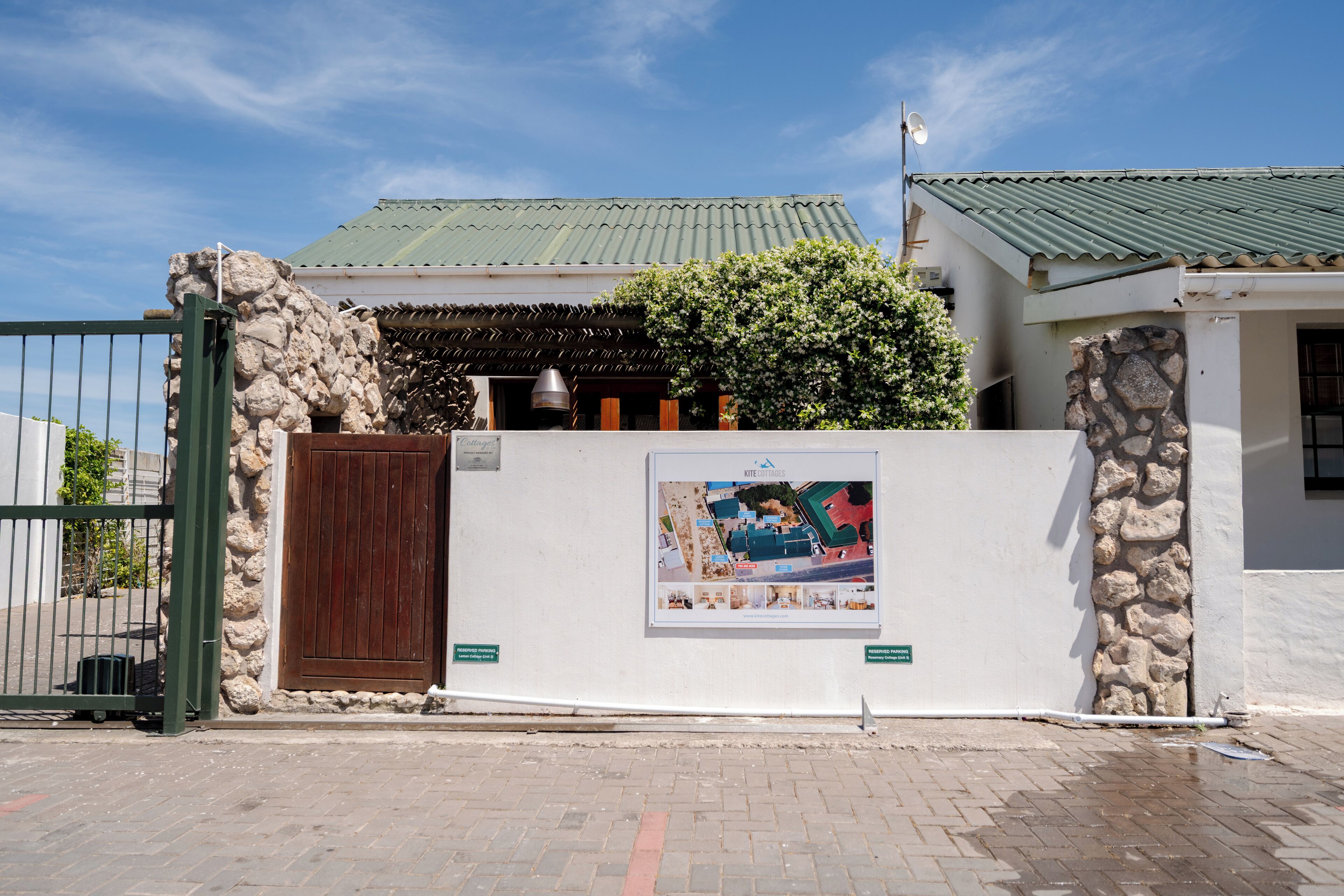Un edificio con pared de piedra, puerta de madera y un cartel en la pared.