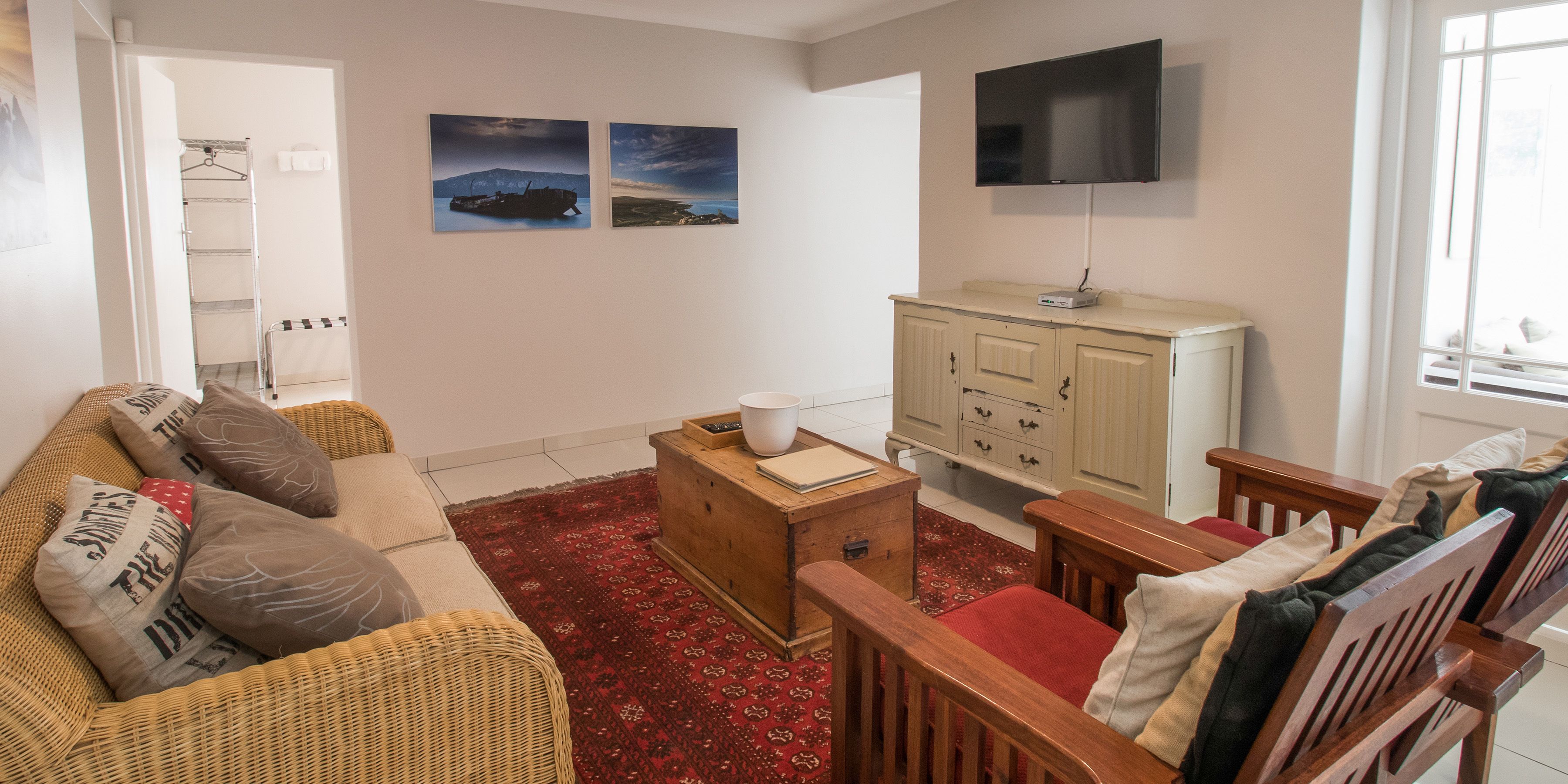 A living room with a sofa, wooden cabinet, and a television.