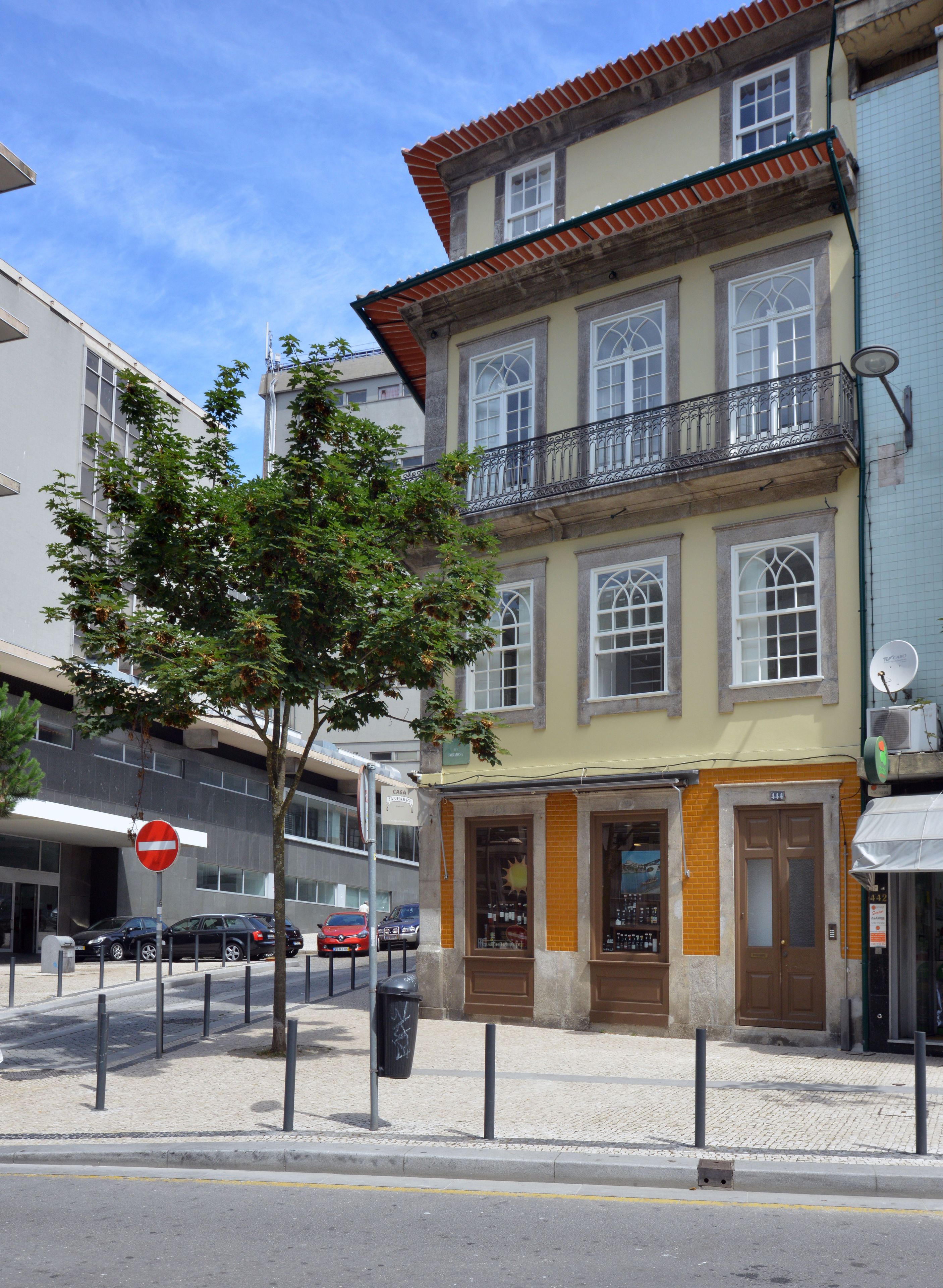 Ein Gebäude mit traditioneller Fassade, zahlreichen Fenstern und einem Balkon.