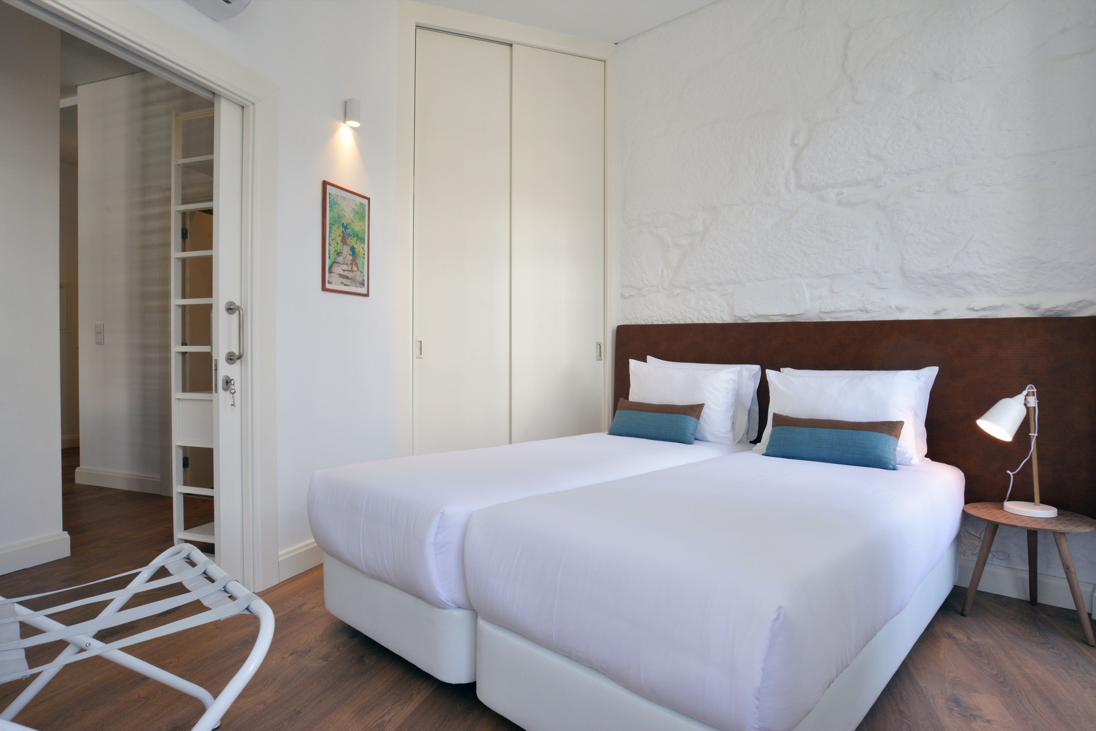 A bedroom with a bed, bedside table, and a wardrobe.